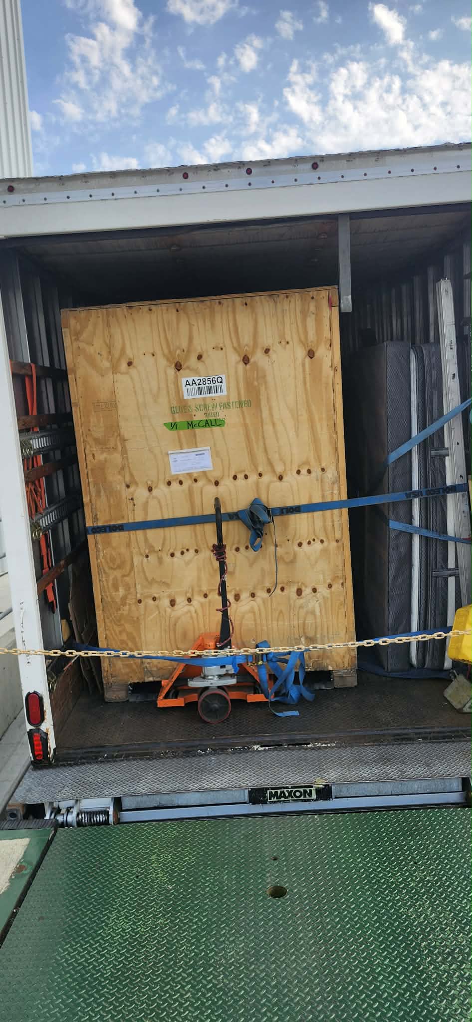 Custom-built wooden crate secured on truck liftgate