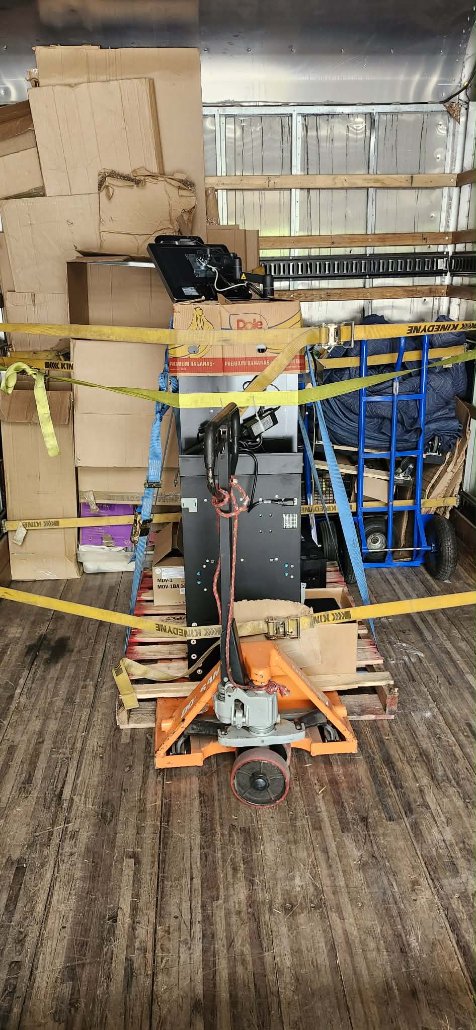 Heavy equipment secured with straps on a pallet jack