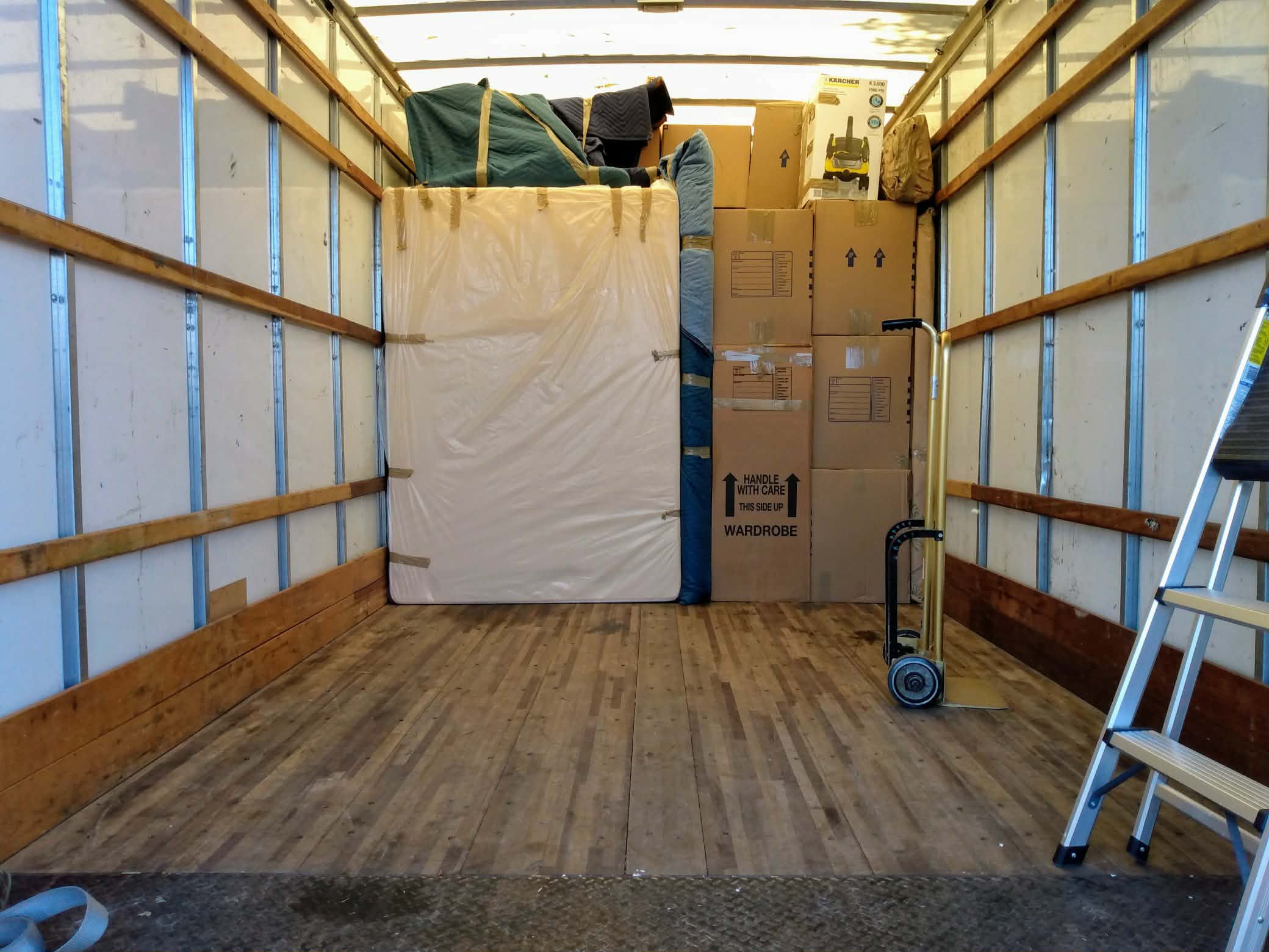 Inside Black Crow moving truck with mattress and wardrobe boxes carefully loaded
