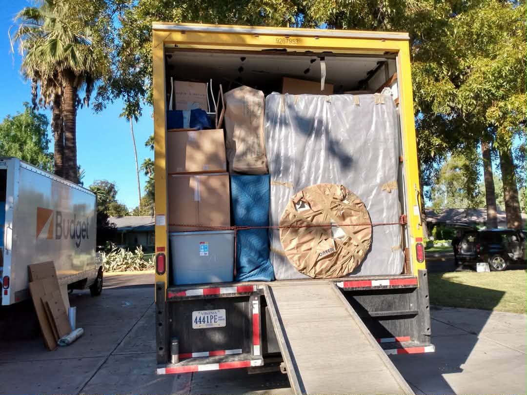 Fully loaded Black Crow Moving truck with ramp down ready for long-distance transport